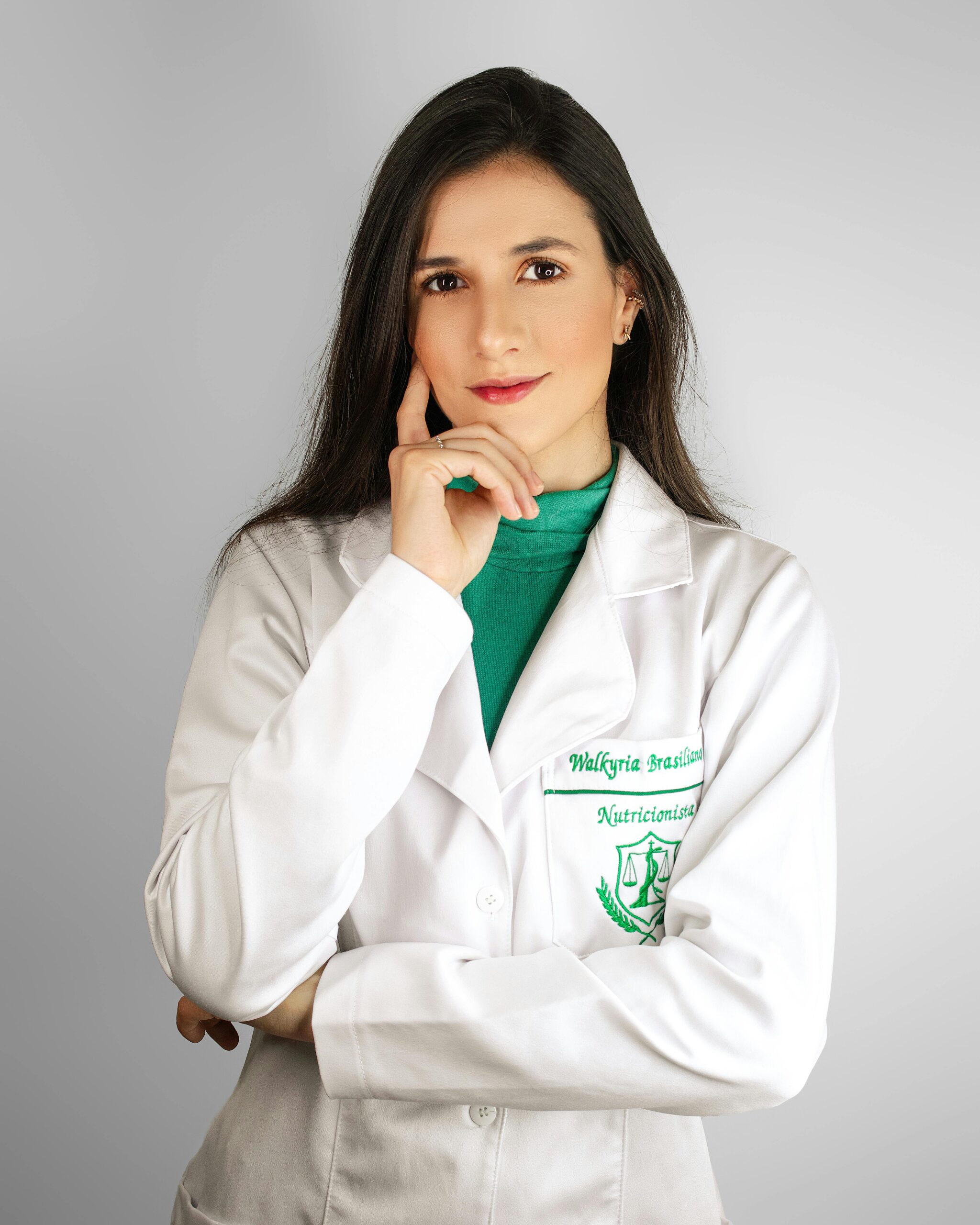 Portrait of a female healthcare professional in a white lab coat in a studio setting.